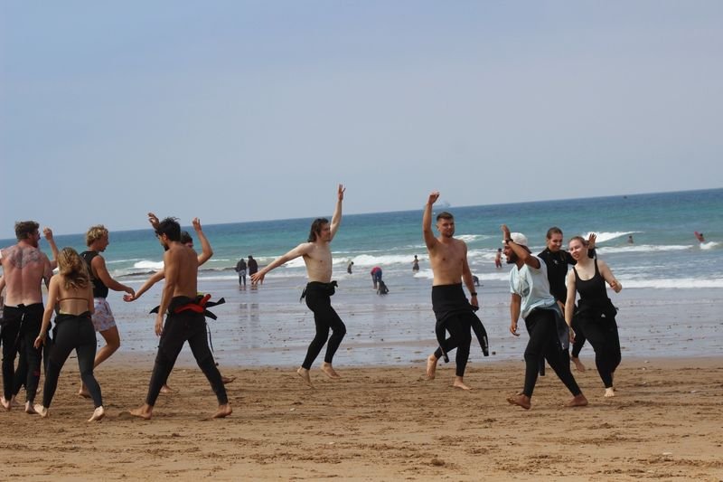 Calentamiento en grupo en la playa antes de la sesión de surf