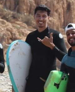Yahya, coach at the Taghazout hostel, on the beach with his board