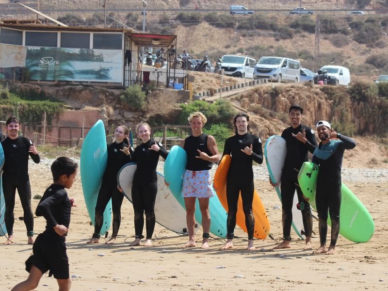 A surf group with their boards on the beach after the morning session