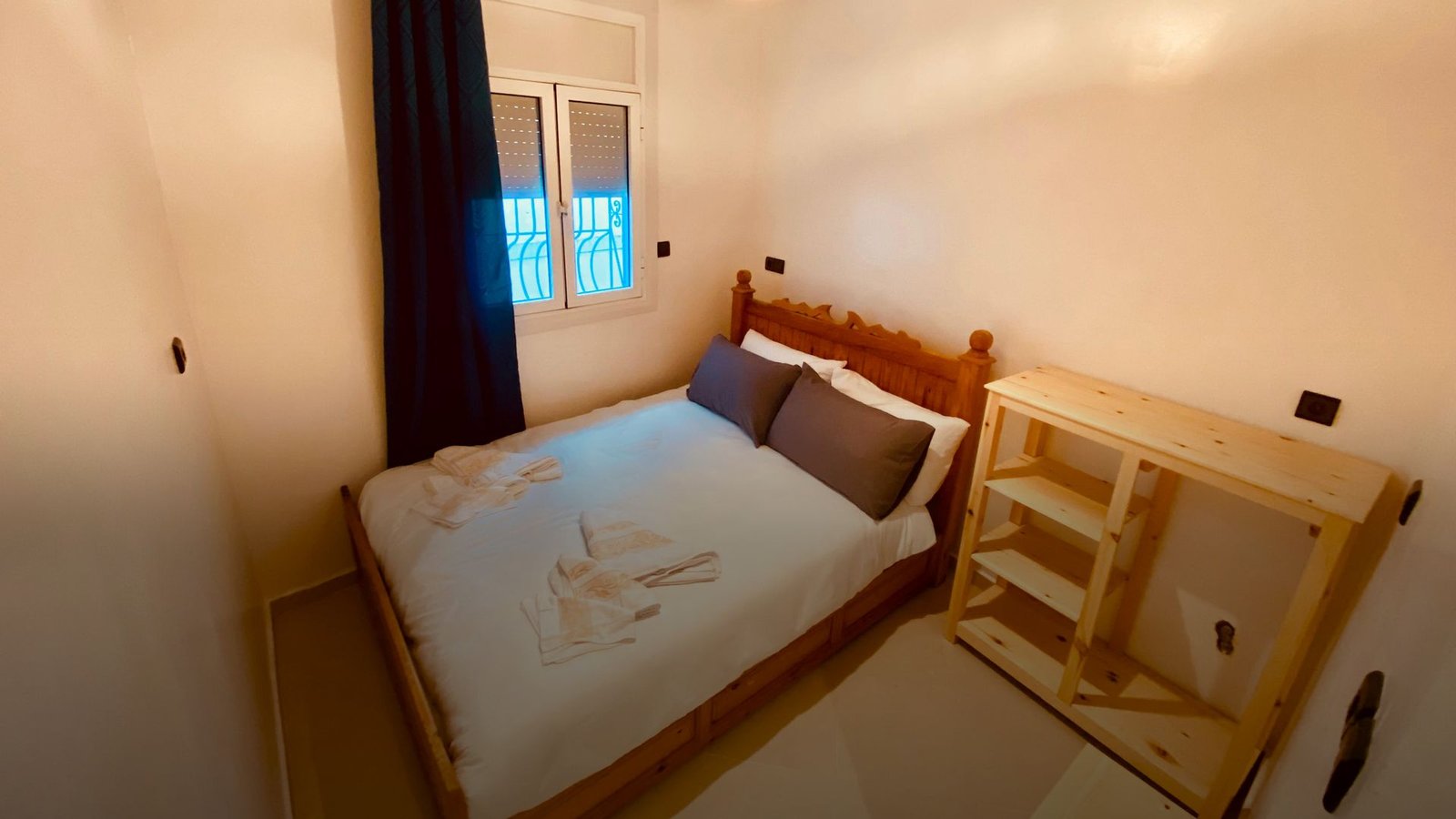Ein Doppelzimmer im Hostel in Taghazout: frisch bezogenes Bett, warmes Licht