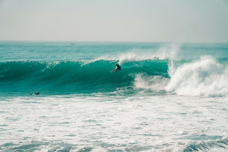 Ein Surfer in einer grünen Welle am Anchor Point, Taghazout