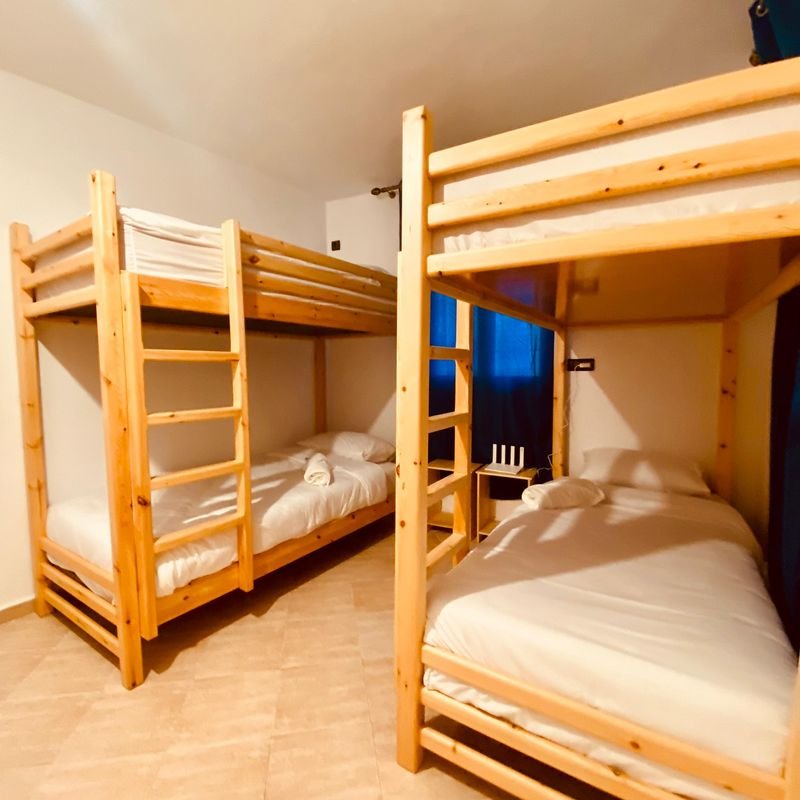 Women-only dorm at the Taghazout hostel: pine bunk beds with white bedding