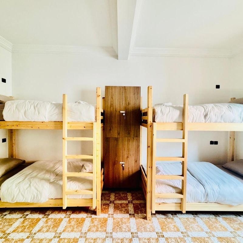 Gemischtes Mehrbettzimmer im Hostel Tamraght: zwei Kiefern-Stockbetten auf gemustertem Fliesenboden