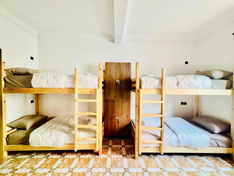 Gemischtes Mehrbettzimmer im Hostel Tamraght: zwei Kiefern-Stockbetten auf gemustertem Fliesenboden