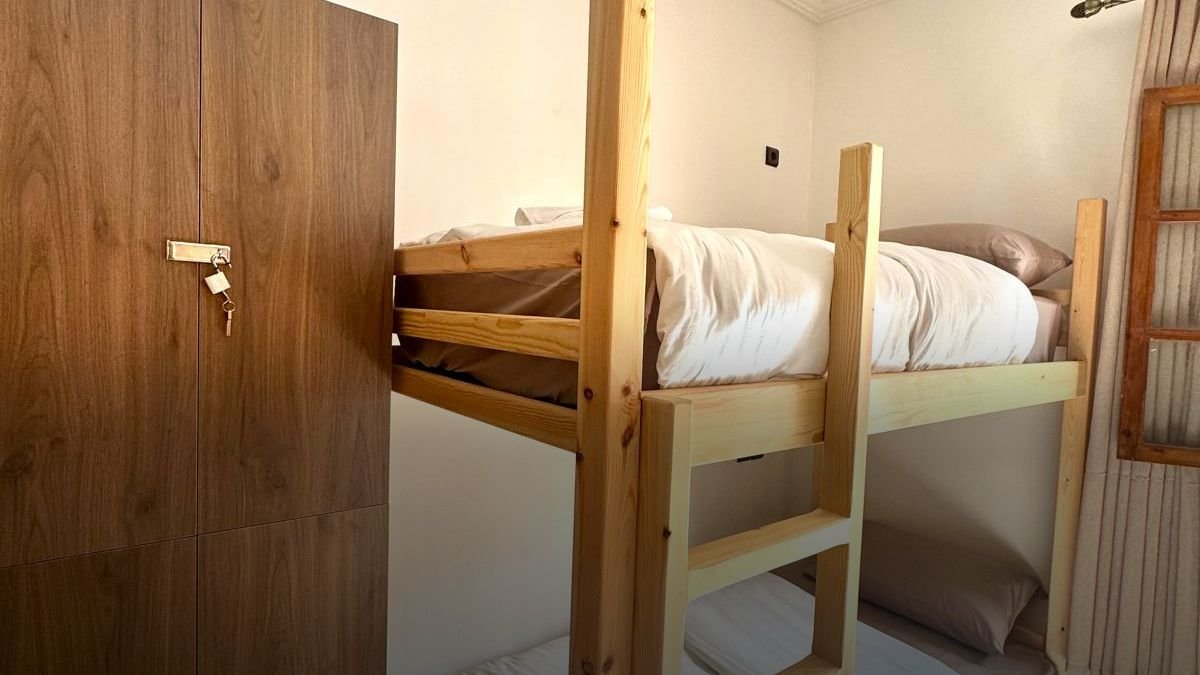 Women-only dorm at the Tamraght hostel: a pine bunk bed and a wooden wardrobe